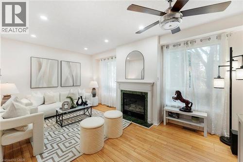 Hardwood flooring, recessed lighting, ceiling fan, fireplace with green stone surround, and a mantel with a decorative mirror - 123 Brickyard Way, Brampton, ON 