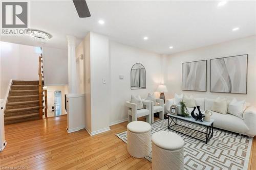 Wood-finish flooring, recessed lighting, ceiling fan, carpeted staircase with wood handrails, and a decorative ceiling fixture - 123 Brickyard Way, Brampton, ON 