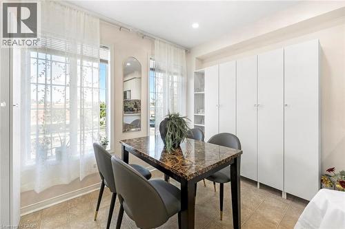 Built-in white cabinetry with open shelving, large windows, and tile flooring - 123 Brickyard Way, Brampton, ON 