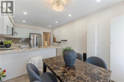 Kitchen featuring recessed lighting, a crystal chandelier, light-colored cabinetry, stainless steel appliances, and a tiled backsplash - 123 Brickyard Way, Brampton, ON 