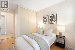 Light wood-finish flooring, sliding closet doors, and warm neutral wall color - 