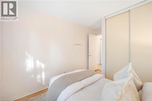 Light-colored walls, wood-finish flooring, and sliding wardrobe doors - 123 Brickyard Way, Brampton, ON 