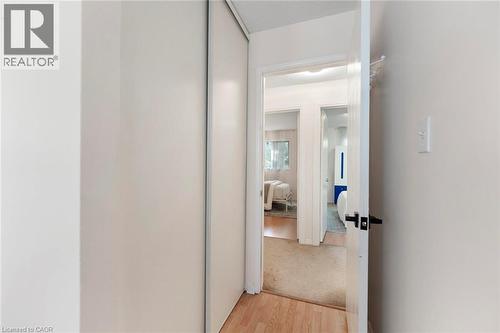 Sliding closet doors, light-toned wood-finish flooring, and white walls - 123 Brickyard Way, Brampton, ON 