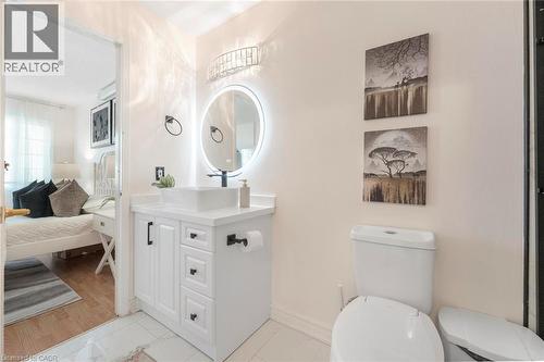 White vanity with black hardware, vessel sink, and illuminated circular mirror - 123 Brickyard Way, Brampton, ON 