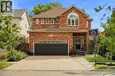 Brick exterior with an arched window, attached garage, and paved driveway - 167 Broadoaks Drive, Cambridge, ON 