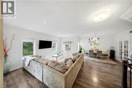 Open-concept living space featuring wood-finish flooring, recessed lighting, and a crystal chandelier - 167 Broadoaks Drive, Cambridge, ON 