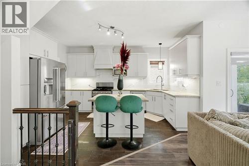 White cabinetry with under-cabinet lighting, stainless steel appliances, and a central island with a built-in cooktop - 167 Broadoaks Drive, Cambridge, ON 