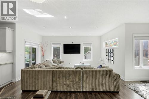 Recessed ceiling lighting, wood-finish flooring, white cabinetry with under-cabinet lighting, and a sliding glass door - 167 Broadoaks Drive, Cambridge, ON 