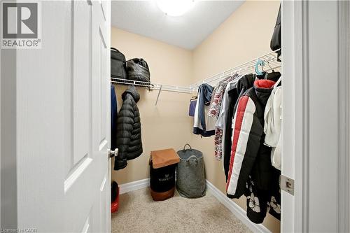 Walk-in closet featuring wire shelving, hanging rods, and neutral carpeting - 167 Broadoaks Drive, Cambridge, ON 