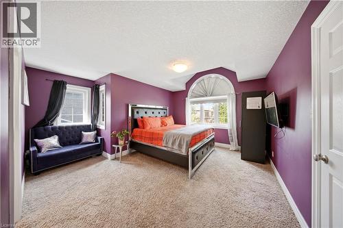 Carpeted room featuring a large arched window with horizontal blinds, additional window, and a built-in ceiling light fixture - 167 Broadoaks Drive, Cambridge, ON 