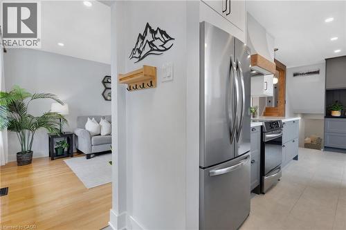 Stainless steel refrigerator, gray lower cabinetry, light wood-finish flooring, recessed lighting, and white baseboards - 477 Kingscourt Drive Unit# B, Waterloo, ON 