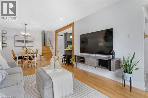 Open-concept living area featuring hardwood flooring, recessed lighting, a modern chandelier, and a built-in media console - 477 Kingscourt Drive Unit# B, Waterloo, ON 