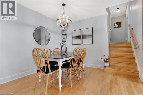 Wood-finish flooring throughout, complemented by a contemporary chandelier - 477 Kingscourt Drive Unit# B, Waterloo, ON 