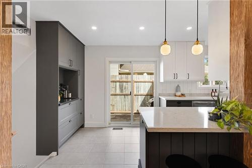 Kitchen featuring a sliding glass door, recessed lighting, white upper cabinetry, and a kitchen island with a light-colored countertop - 477 Kingscourt Drive Unit# B, Waterloo, ON 