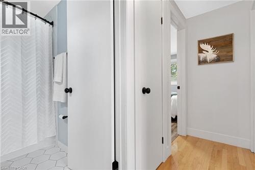 Light wood-finish flooring, white doors with matte black hardware, and hexagonal tile flooring in the bathroom - 477 Kingscourt Drive Unit# B, Waterloo, ON 