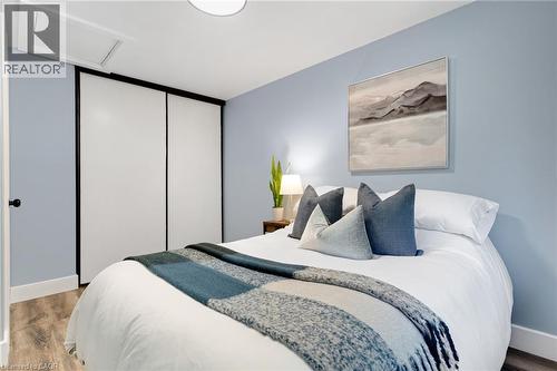Room featuring wood-finish flooring, a flush-mount ceiling light, and a built-in closet with sliding doors - 477 Kingscourt Drive Unit# B, Waterloo, ON 
