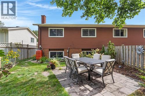 Paver patio with a surrounding lawn, privacy fencing, and a red brick chimney - 477 Kingscourt Drive Unit# B, Waterloo, ON 