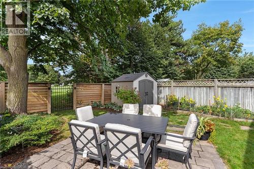 Paver patio with a substantial tree, fenced perimeter, and a storage shed - 477 Kingscourt Drive Unit# B, Waterloo, ON 