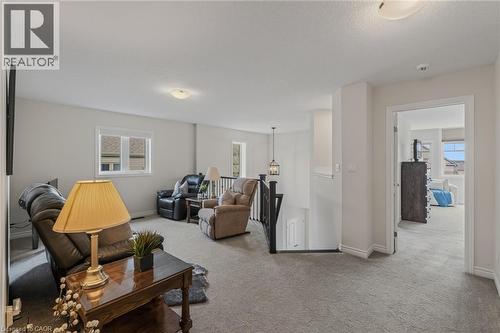 Spacious upper-level landing featuring neutral carpeting and light-toned walls - 249 Woodway Trail, Simcoe, ON 
