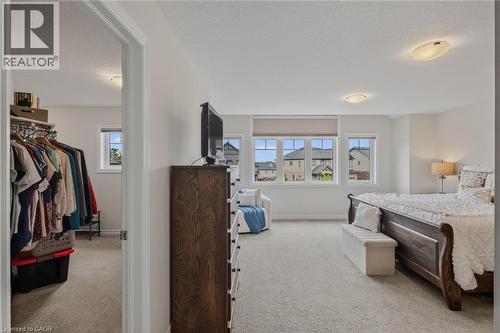 Spacious room featuring light-colored carpeting, multiple windows with roller shades, and a ceiling-mounted light fixture - 249 Woodway Trail, Simcoe, ON 