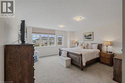 Carpeted room with multiple windows, recessed lighting, and neutral wall tones - 