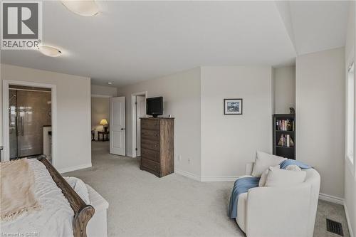 Carpeted bedroom featuring a wood bed frame and a semi-flush mount ceiling light - 249 Woodway Trail, Simcoe, ON 