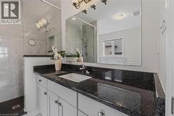 Bathroom vanity with a dark speckled countertop, undermount sink, and chrome faucet - 
