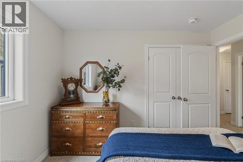 Bedroom featuring a double-pane window, neutral wall paint, white trim, and carpeted flooring - 249 Woodway Trail, Simcoe, ON 