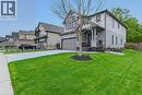 Modern colonial-style exterior featuring a prominent gabled roofline, stone and siding facade, covered porch entry, two-car garage, and a concrete driveway - 249 Woodway Trail, Simcoe, ON 