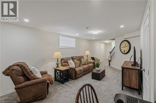 Spacious recreation room featuring light gray carpet, recessed lighting, and a white trim window - 249 Woodway Trail, Simcoe, ON 