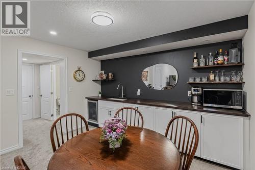 Entertainment area featuring white base cabinetry, a built-in beverage cooler, and a single-basin sink with a gooseneck faucet - 249 Woodway Trail, Simcoe, ON 