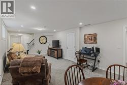 Finished living space with light gray wall paint and matching carpet flooring - 