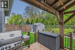 Covered wood-finish deck with a corrugated metal ceiling and a privacy screen - 