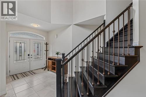 Entry foyer featuring a dark wood staircase with ornate metal balusters - 249 Woodway Trail, Simcoe, ON 