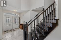 Entry foyer featuring a dark wood staircase with ornate metal balusters - 
