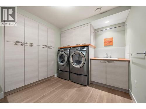 Lower level Laundry room with built in cabinetry, front loading washer and dryer and sink - 2442 Bella Vista Street, Kelowna, BC 