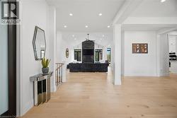 Hardwood flooring extending throughout, vaulted ceilings, recessed lighting, and a modern fireplace with a dark stone surround - 