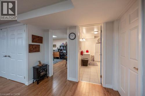 Wood-finish flooring throughout, white paneled doors, and a tiled bathroom with a vanity and mirror - 123 Mill Street, Delhi, ON 
