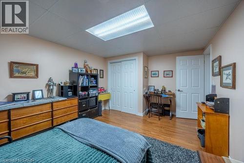 Wood-finish flooring, white paneled doors, ceiling-mounted fluorescent lighting fixture, and a built-in closet with bifold doors - 123 Mill Street, Delhi, ON 