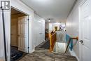 Wood-finish flooring throughout, white paneled doors, and a wood banister with balusters - 123 Mill Street, Delhi, ON 