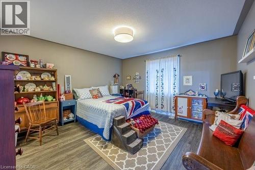 Room featuring wood-finish flooring, neutral wall tones, and a ceiling-mounted light fixture - 123 Mill Street, Delhi, ON 