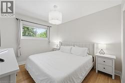 Hardwood-finish flooring, white walls, and a single window with roller shade - 