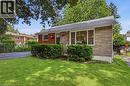 Stone facade exterior with a gabled roofline, front lawn, and mature trees - 312 Upper Paradise Road, Hamilton, ON 