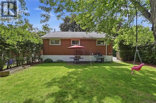 Expansive backyard featuring a manicured lawn, mature trees, and a raised garden bed - 312 Upper Paradise Road, Hamilton, ON 