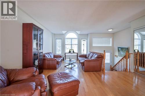 Hardwood flooring, arched transom window, built-in display cabinet, natural light, and wood banister - 12 Langevin Drive, Wasaga Beach, ON 