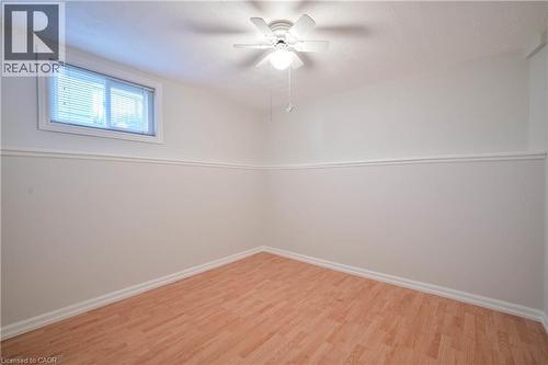 Wood-finish flooring, white walls with chair rail molding, ceiling fan with integrated lighting, and a white-framed window with blinds - 12 Langevin Drive, Wasaga Beach, ON 