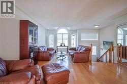 Hardwood flooring, arched transom window, built-in display cabinet, natural light, and wood banister - 