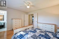 Wood-finish flooring, ceiling fan with integrated lighting, and white paneled doors - 