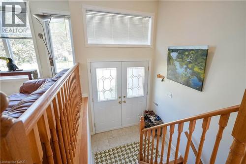 Double entry doors with decorative glass panels, transom window, tile flooring, and wood stair railing - 12 Langevin Drive, Wasaga Beach, ON 