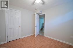 Wood-finish flooring, white paneled doors, ceiling fan with integrated lighting, and white trim - 